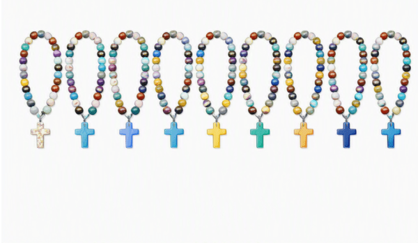 Colorful bead necklaces featuring crosses, arranged in a row. Each necklace has unique colors, highlighting diversity in religious expression.